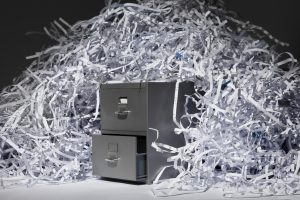 pile of shredded documentation on top of a gray filing cabinet